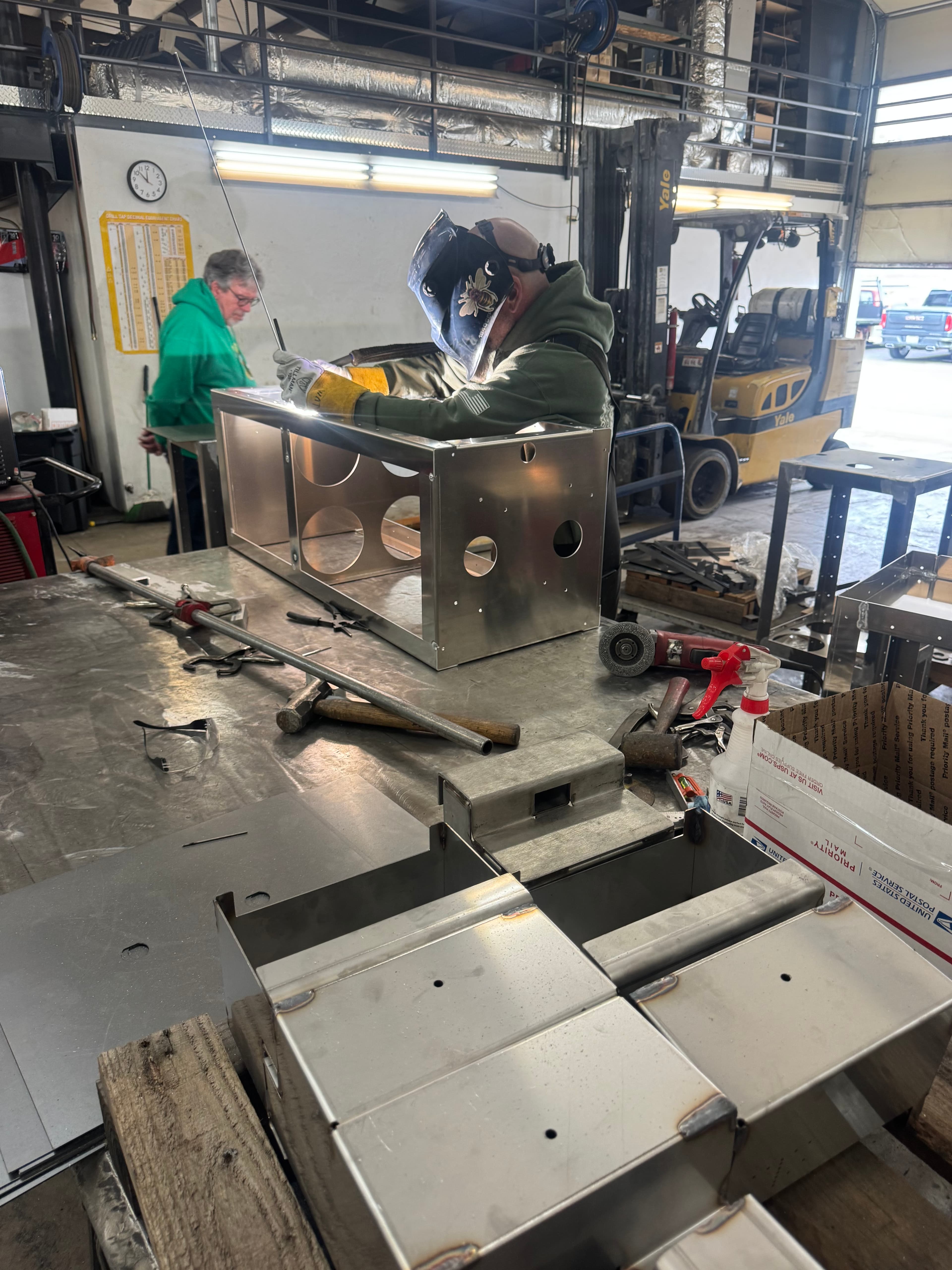 Workers assembling SquareVac units with top plates